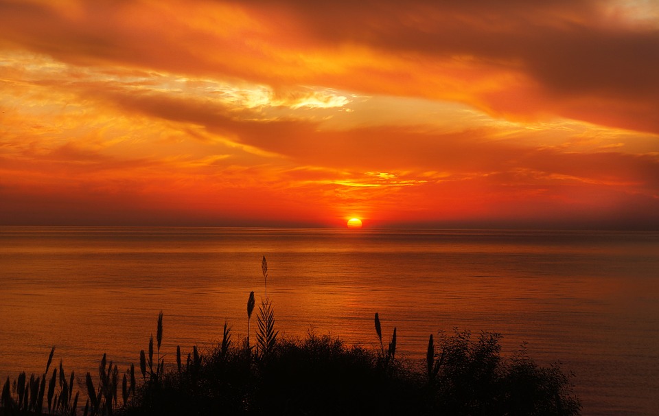 The sun either rising or setting over the water